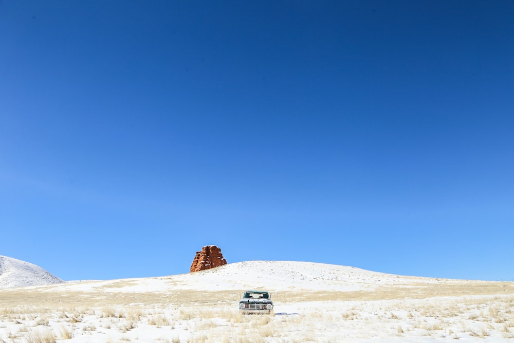 white car on desert under blue sky during daytime