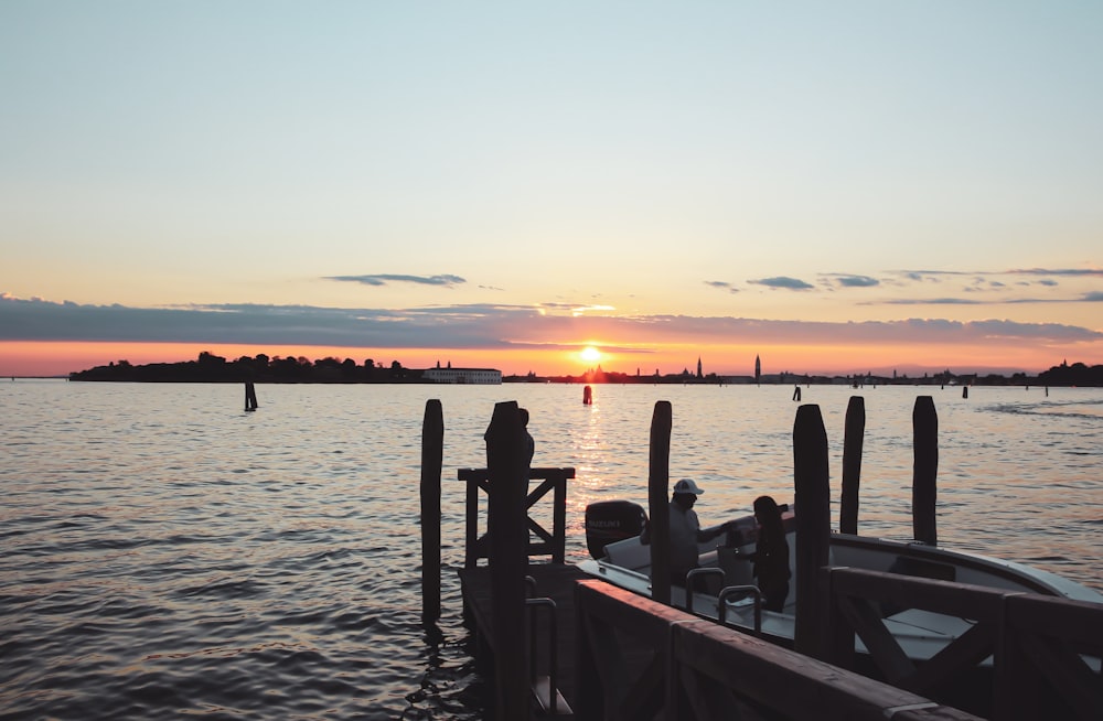 people on boat on sea during sunset