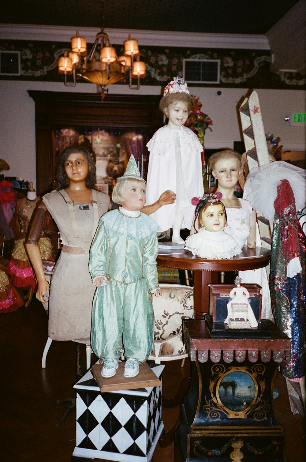 girl in teal dress standing beside girl in white dress figurine