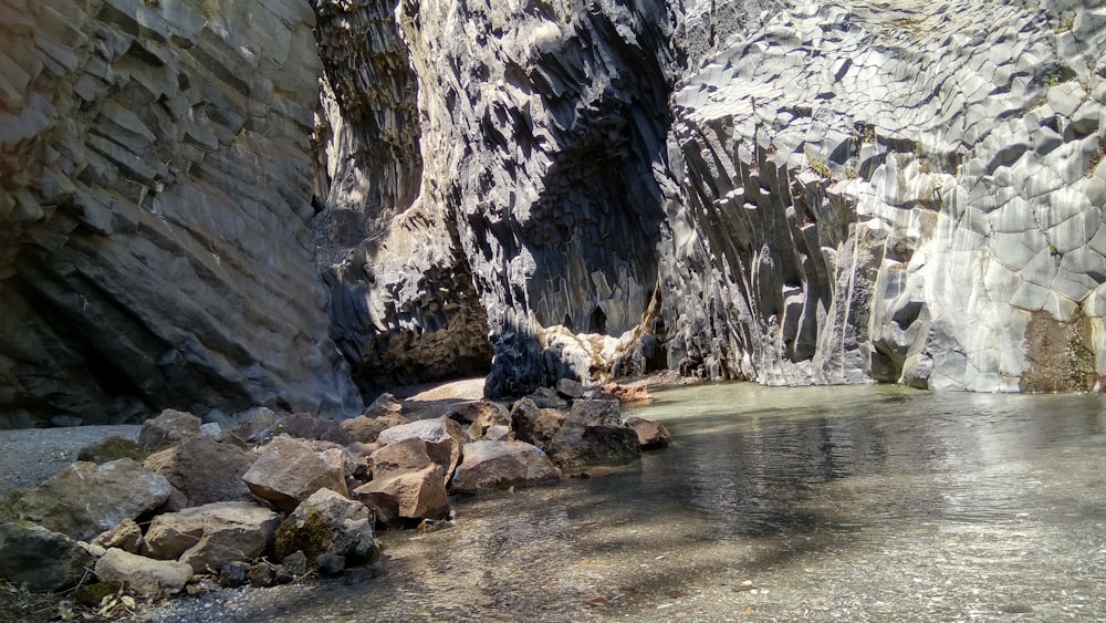 日中の水域近くの灰色の岩山