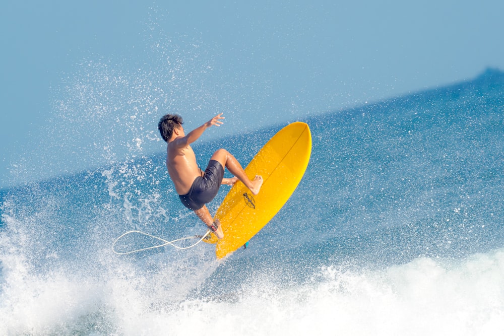 woman in black tank top surfing on sea waves during daytime