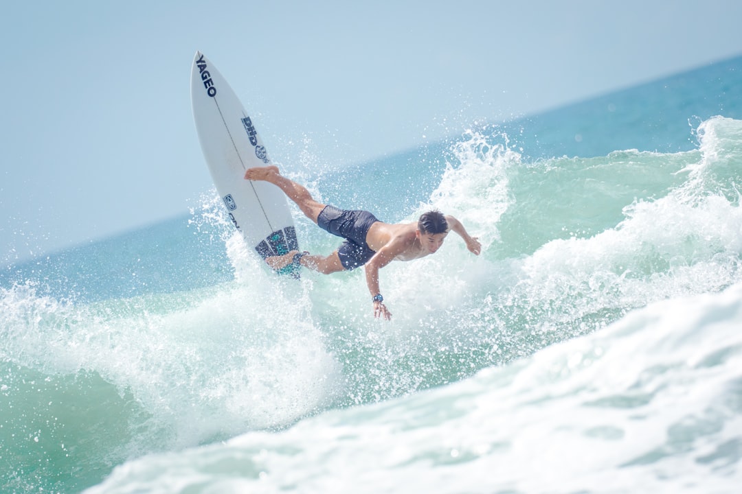 man in black shorts surfing on sea waves during daytime