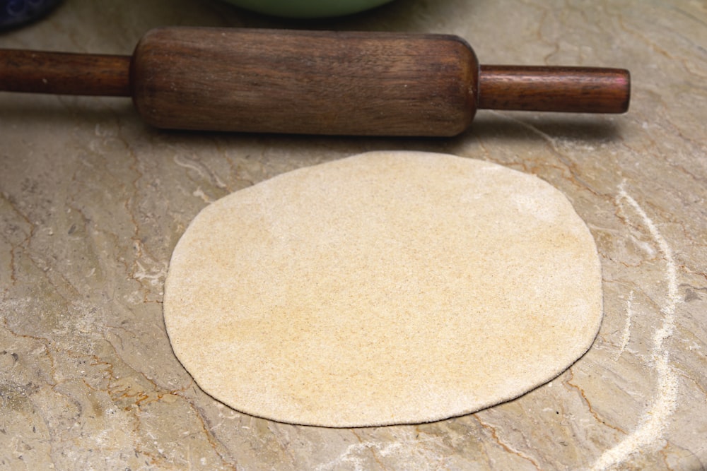 rouleau à pâtisserie en bois brun sur table en bois marron