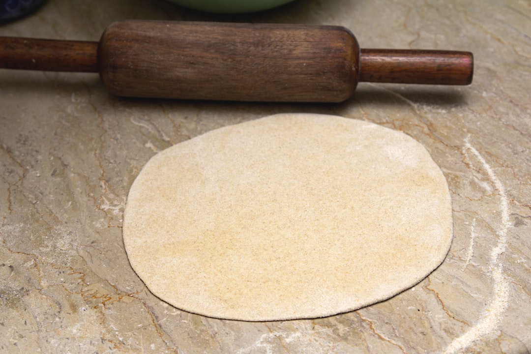 brown wooden rolling pin on brown wooden table, Close shot of an uncooked Asian Bread
