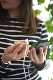 A person using a portable charger outdoors in a city park.