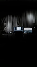 black laptop computer turned on beside black speaker