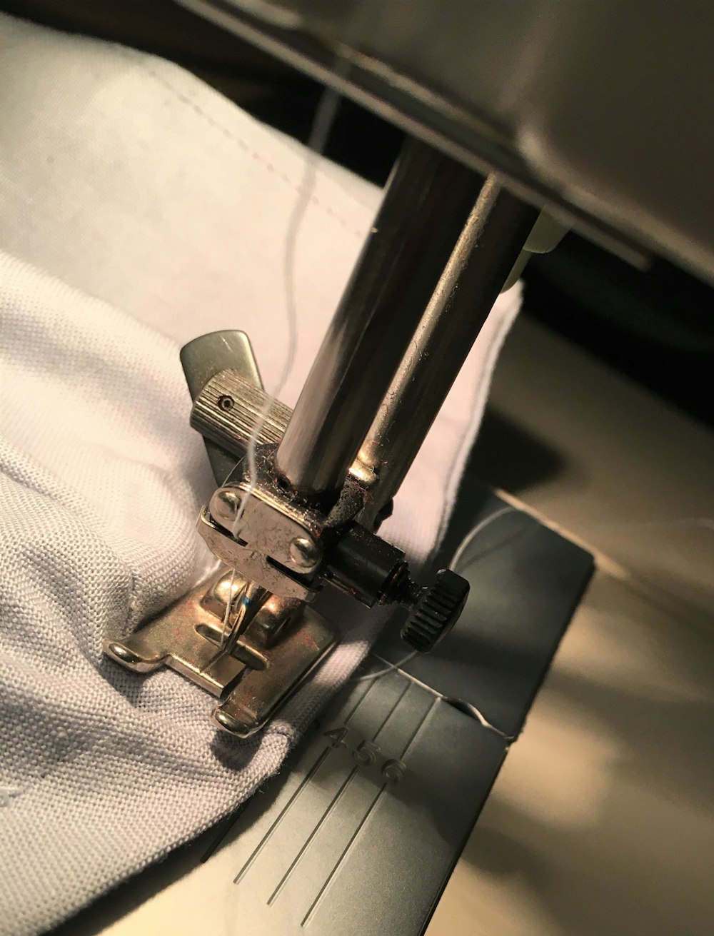 gray metal tool on white textile
