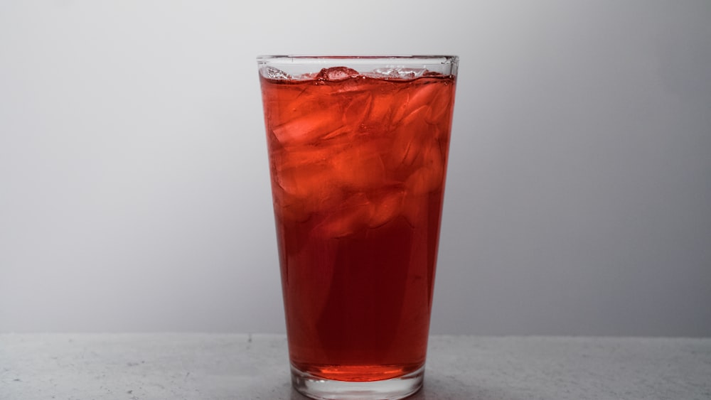 clear drinking glass with brown liquid