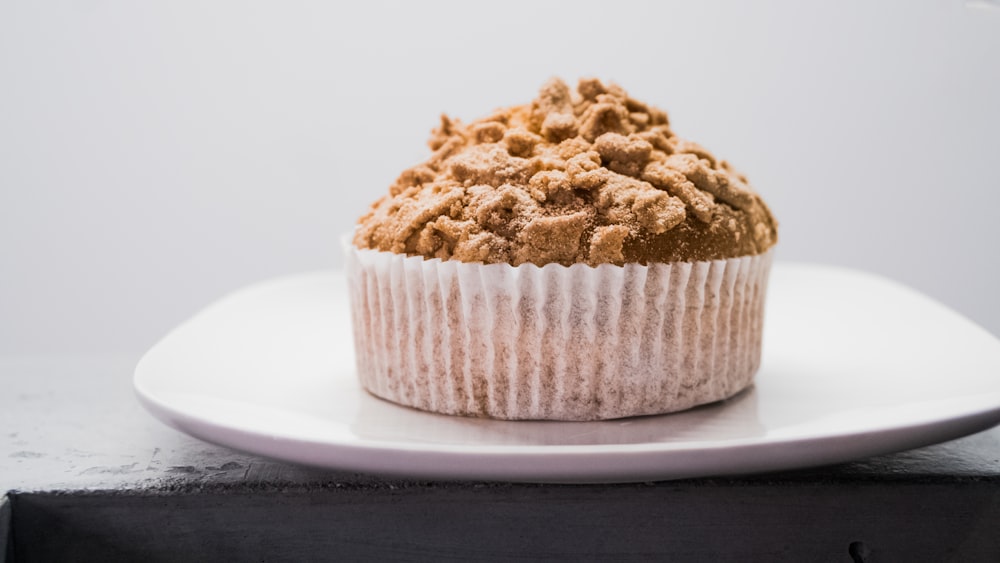 Cupcake brun sur assiette en céramique blanche