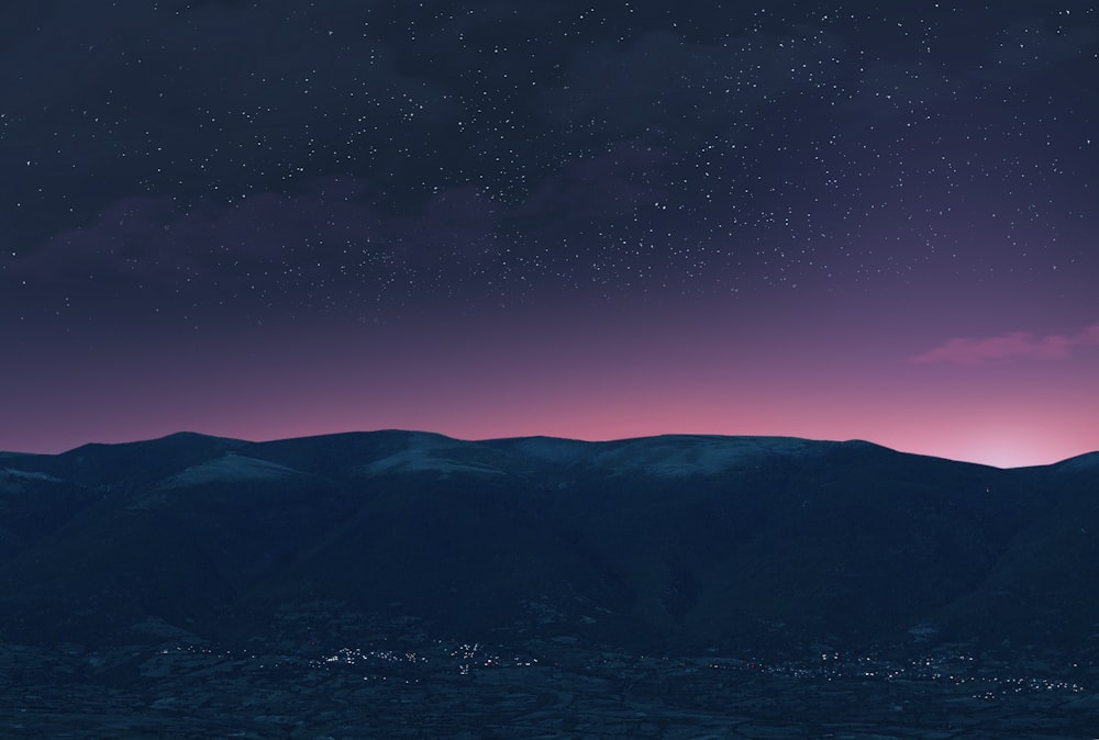 silhouette of mountain under blue sky during night time