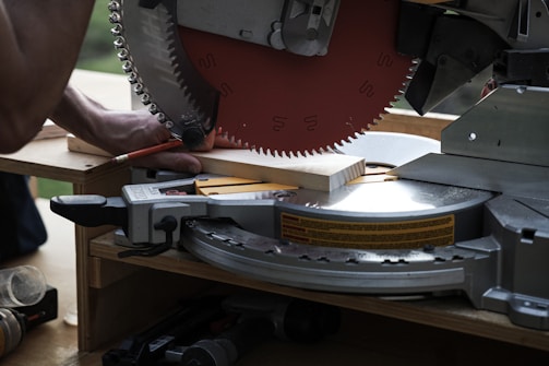 Close-up of a sharp TCT circular saw blade resting on a wooden surface.
