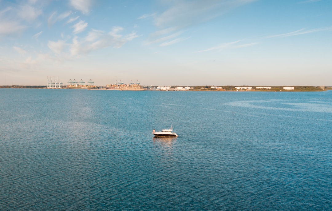 white boat on sea under blue sky during daytime