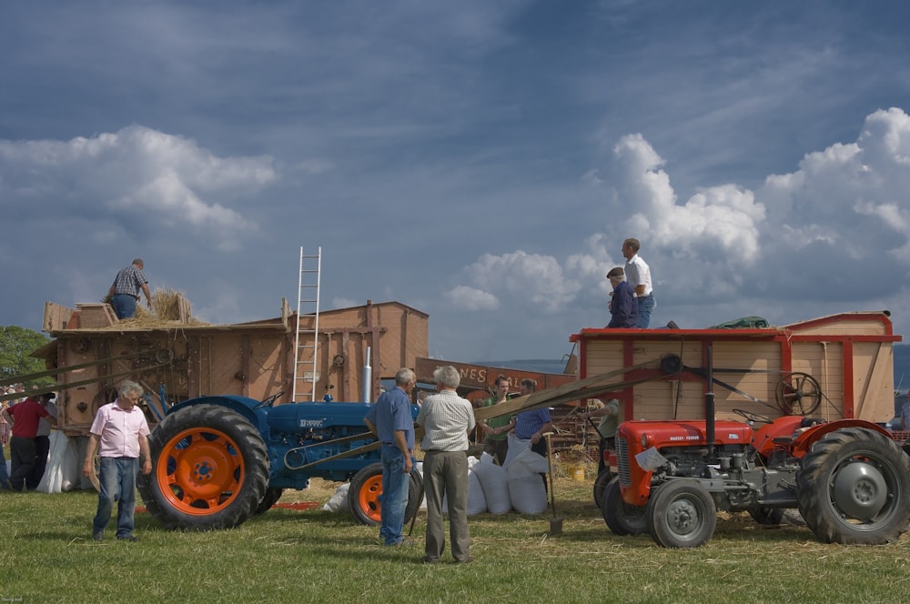 man in white shirt standing near blue tractor during daytime