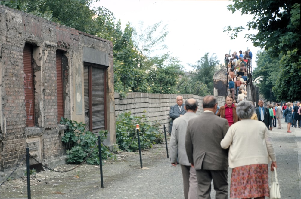 people standing near brown wooden house during daytime
