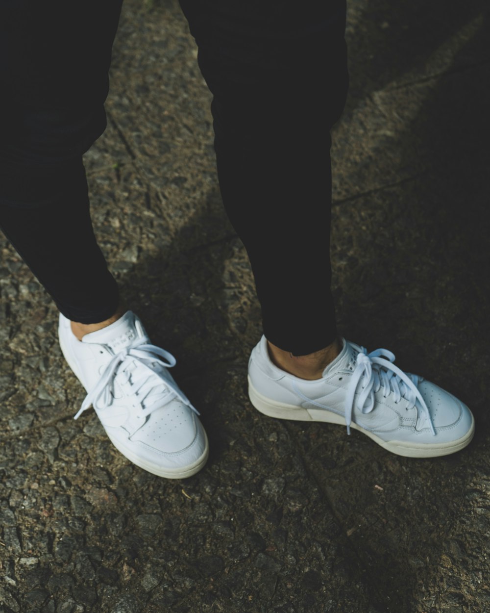 person in black pants wearing white nike sneakers