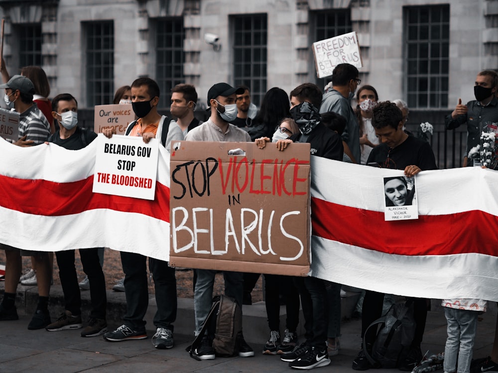 group of people holding red and white banner