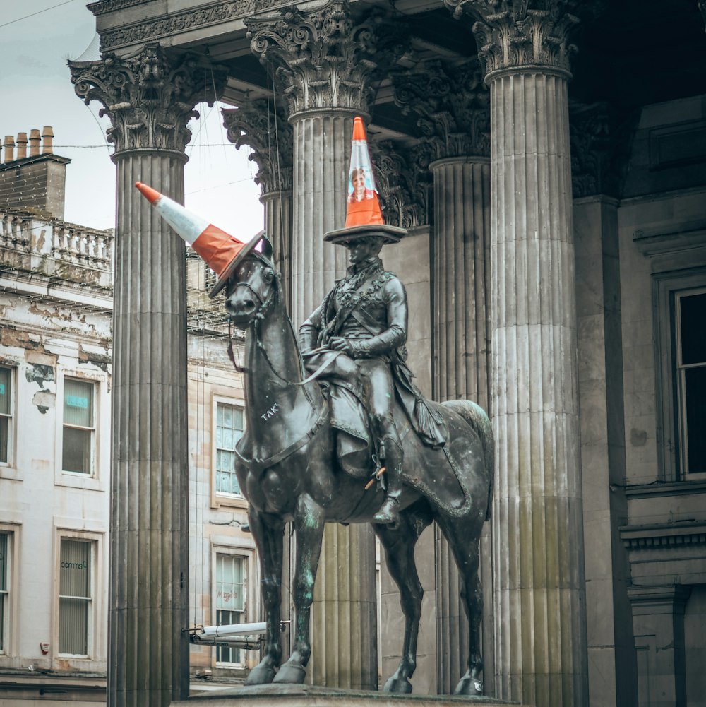 statue of man riding horse near white concrete building during daytime