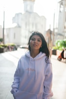 A model wearing a modern, breathable hoodie walking confidently through a bustling city plaza.
