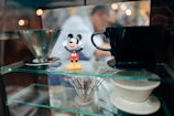Elegant Mickey Mouse mug resting on a navy blue cloth, highlighting gold accents and fine ceramic details.