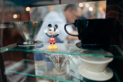 Elegant Mickey Mouse mug resting on a navy blue cloth, highlighting gold accents and fine ceramic details.