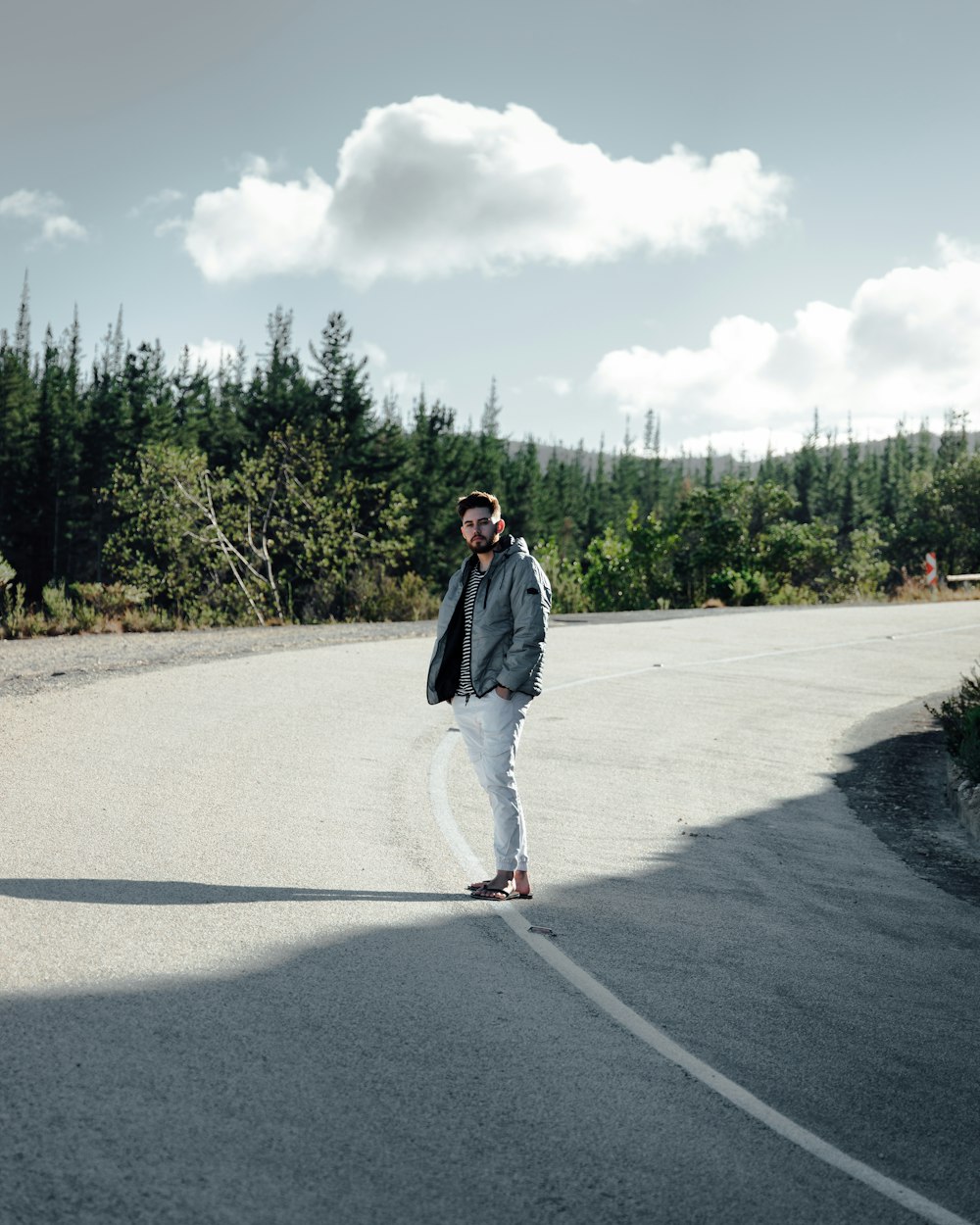 woman in black jacket standing on gray asphalt road during daytime