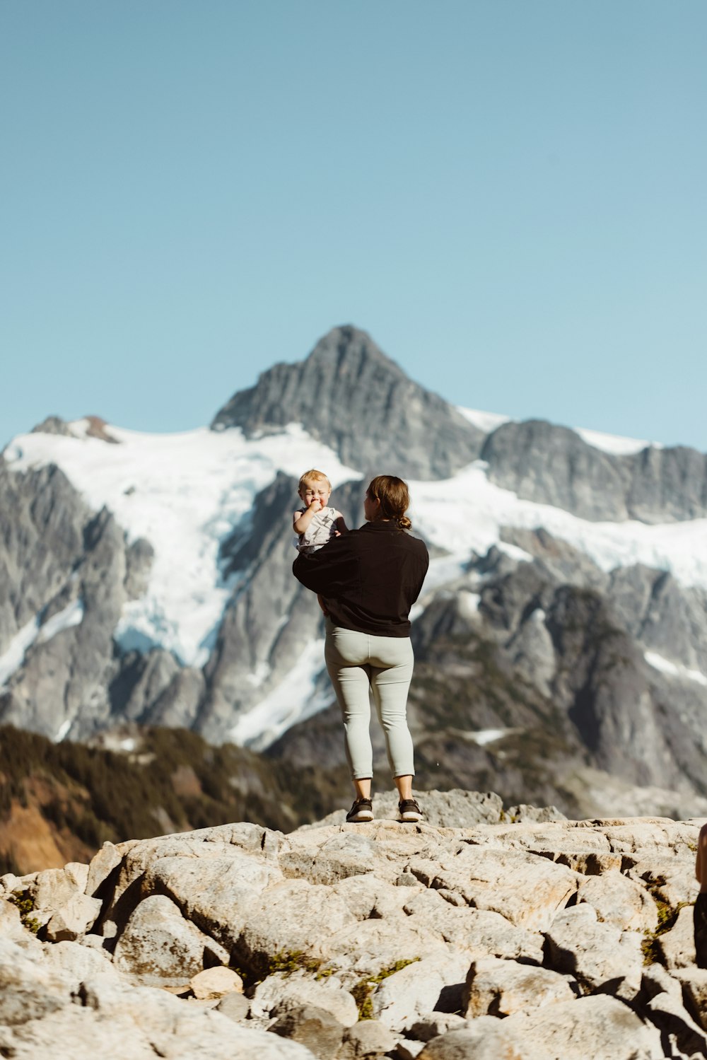 couple kissing on top of mountain during daytime