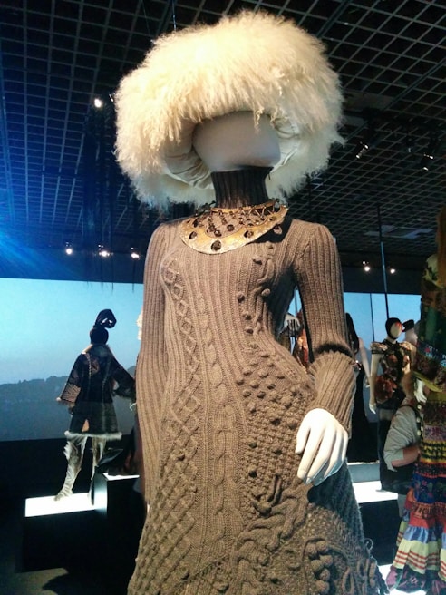 Mannequin displaying a vibrant, handmade dress in a cozy studio setting