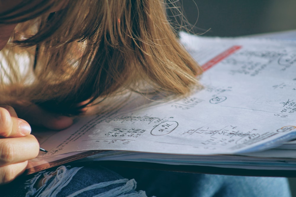 woman in blue denim jacket holding white paper