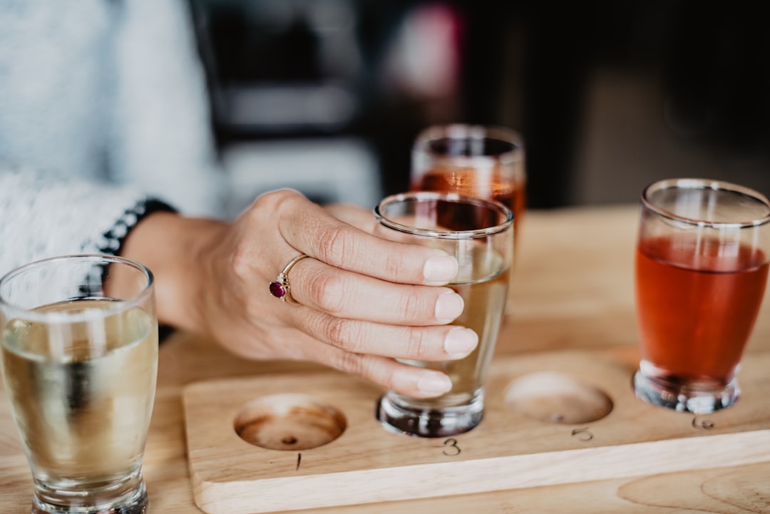 clear drinking glass on brown wooden coaster