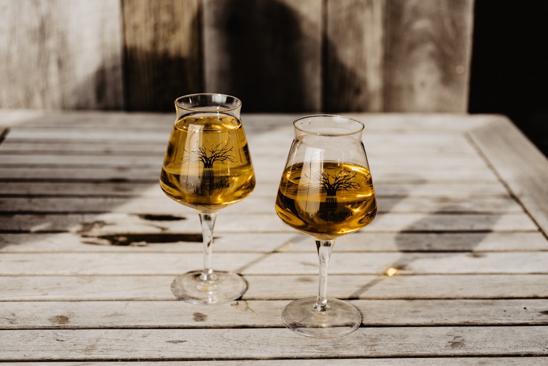 two clear wine glasses on brown wooden table
