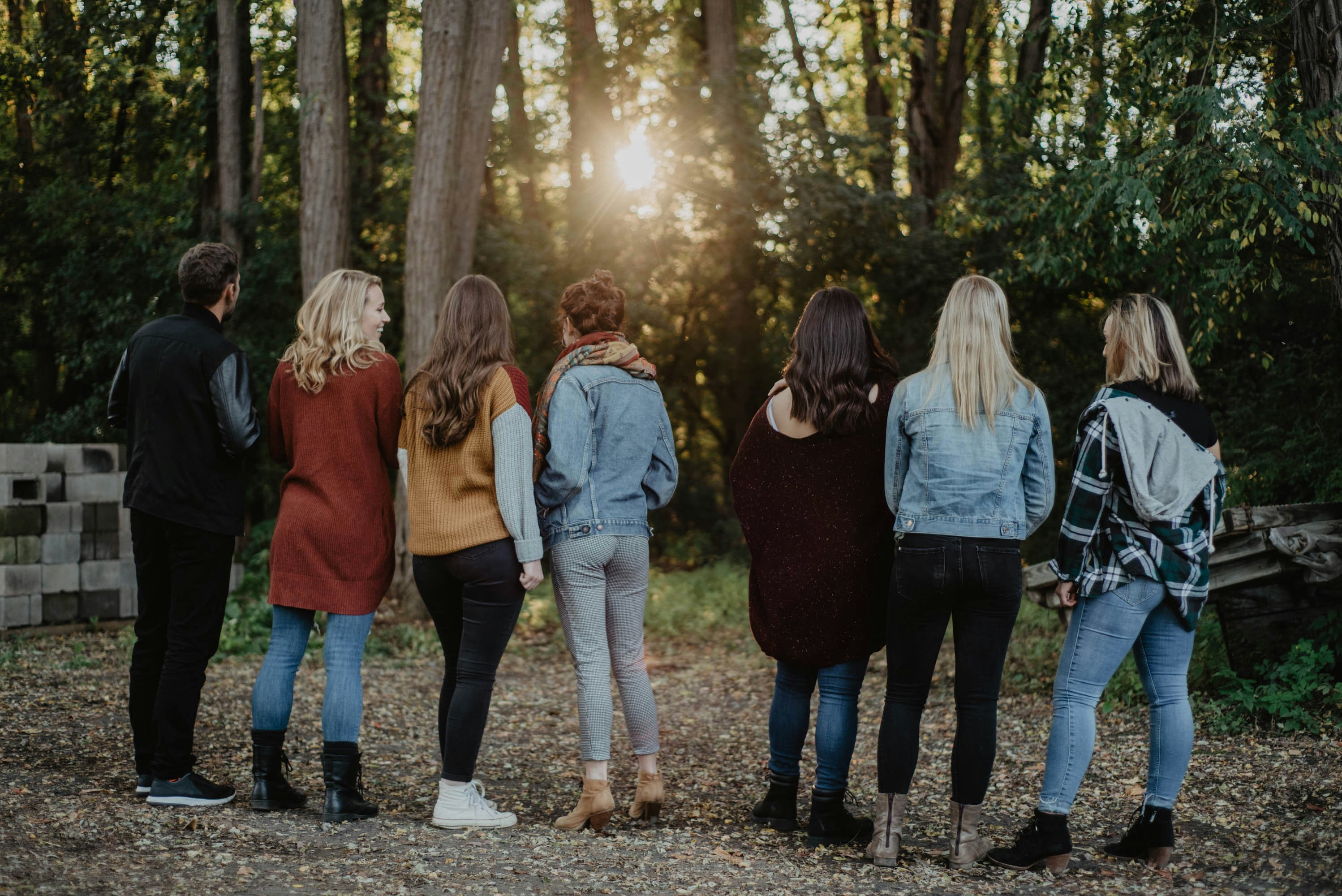 3 women and 2 men walking on forest during daytime