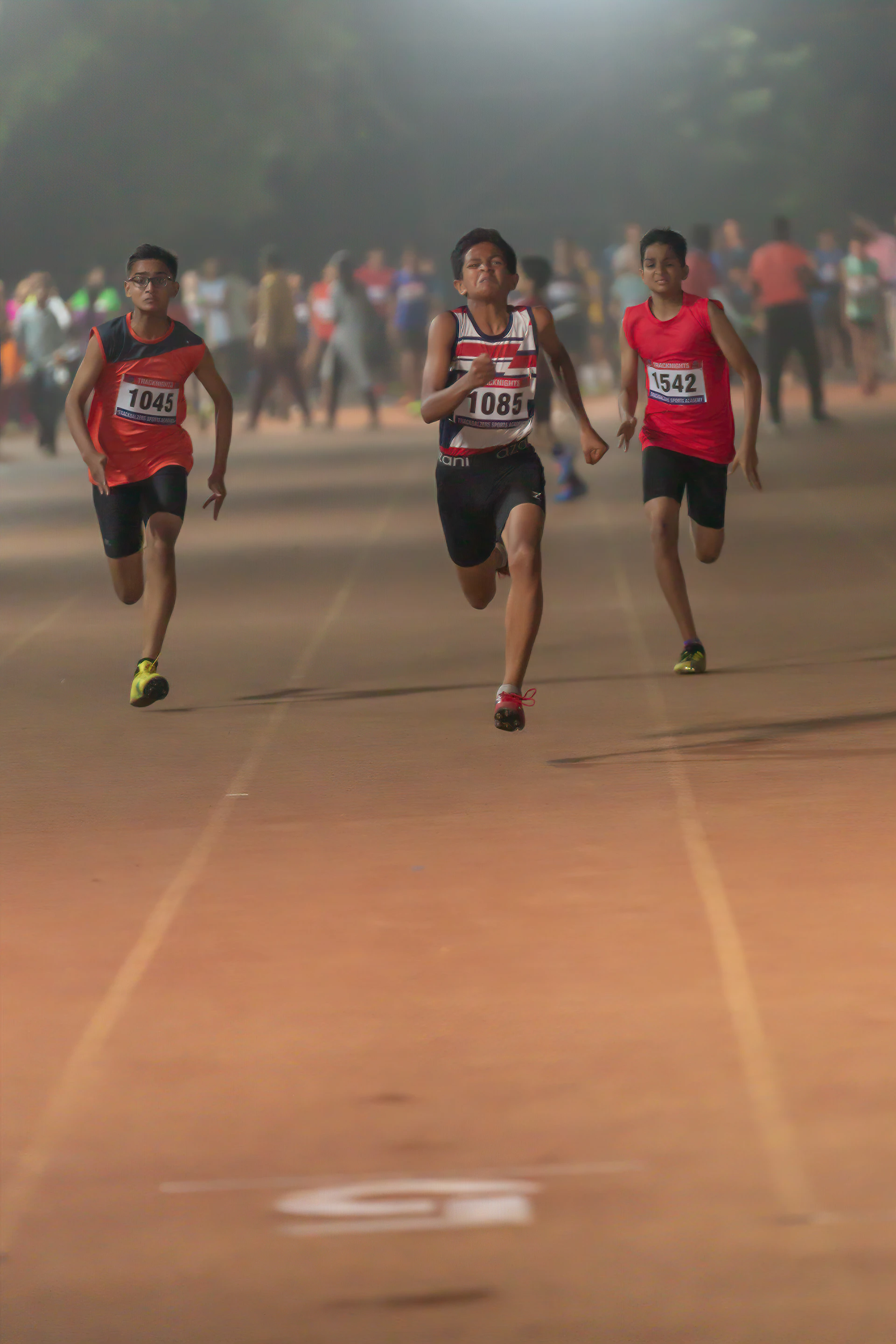 group of people in red and blue jersey shirt running on track field
