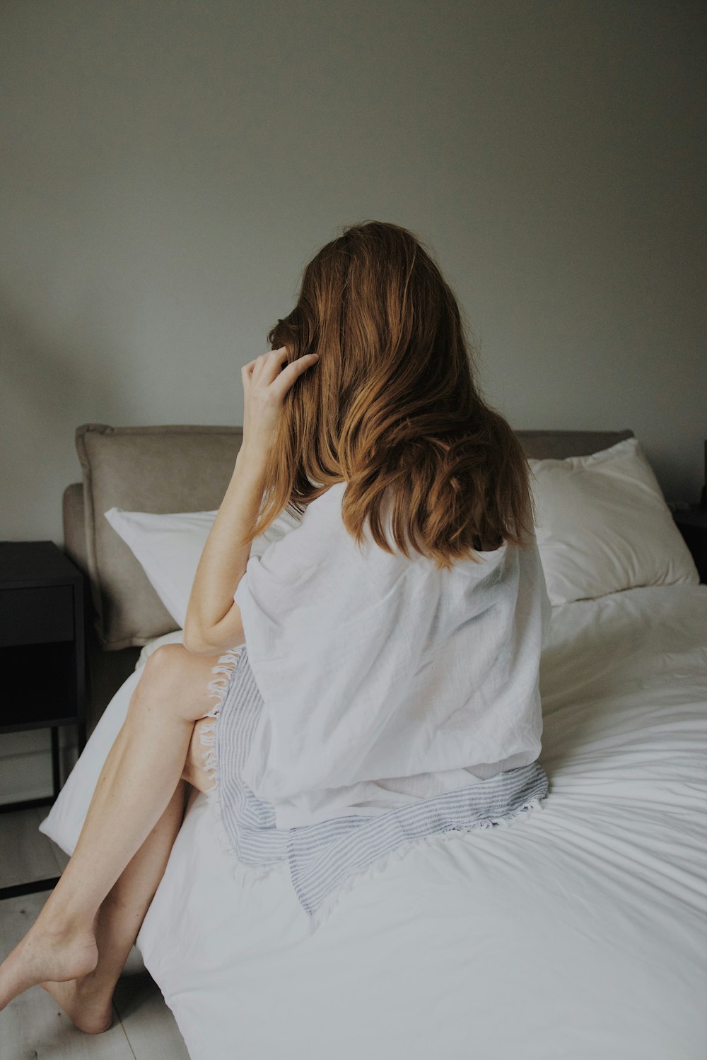 woman in white dress lying on bed