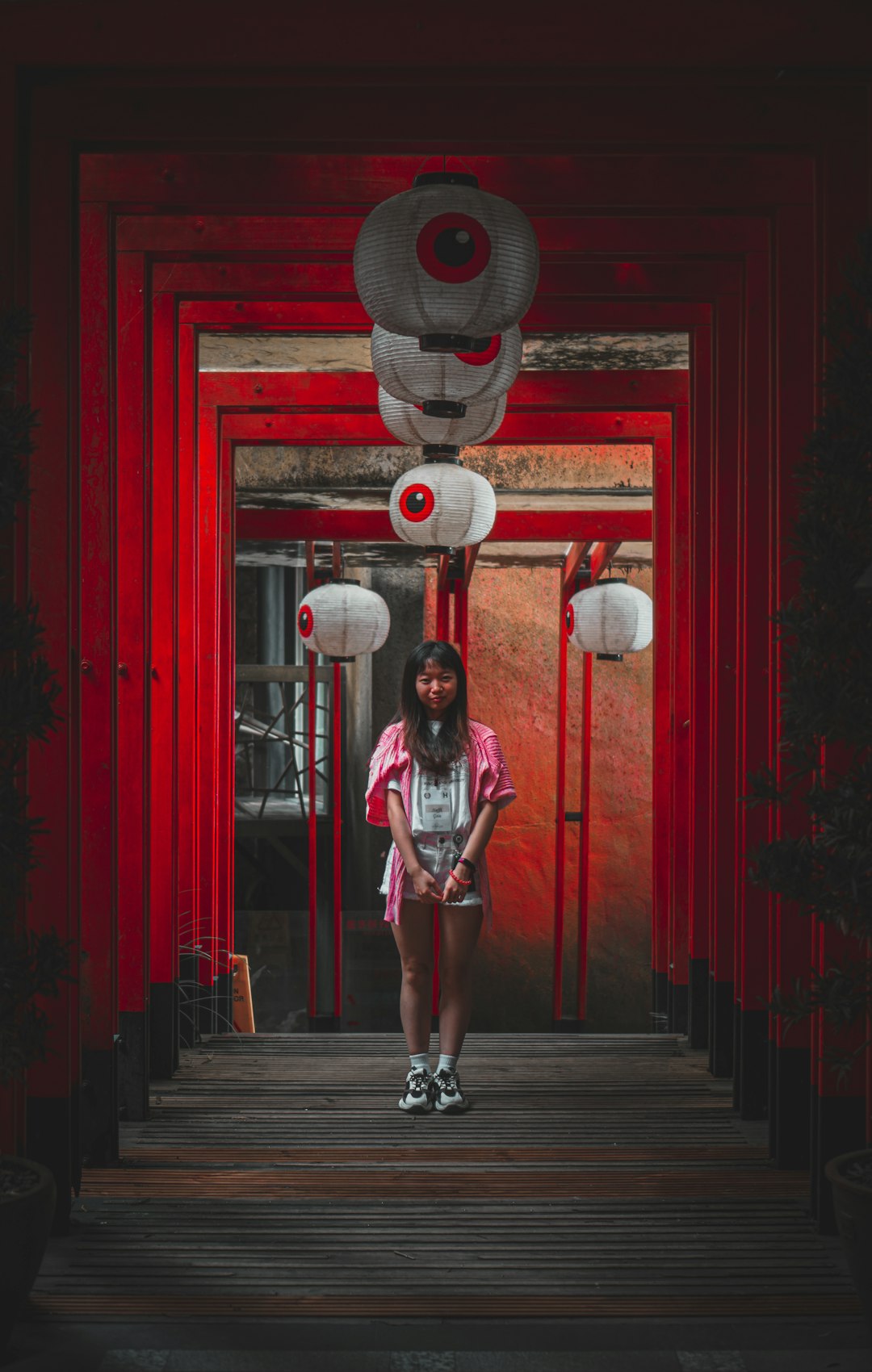 woman in white and black stripe shirt and red shorts standing on brown wooden floor