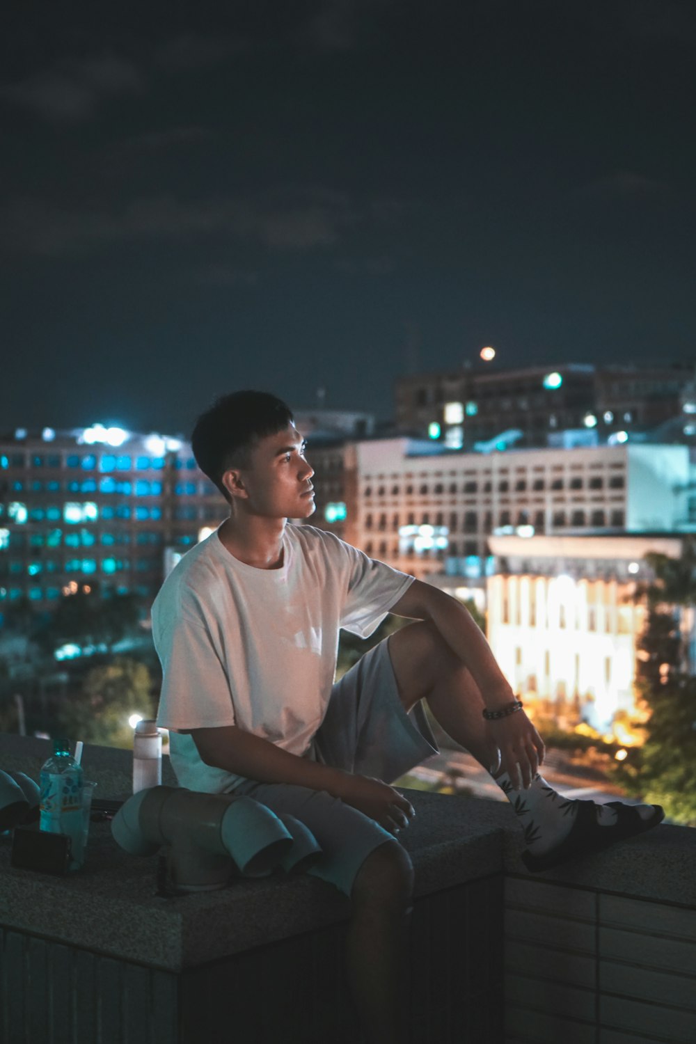 man in white crew neck t-shirt sitting on chair during night time