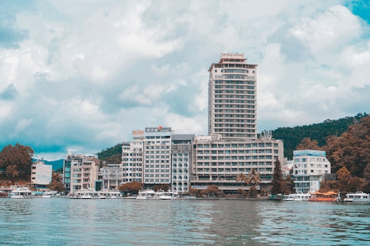 city skyline across body of water during daytime in Shuishe Pier Plaza Taiwan