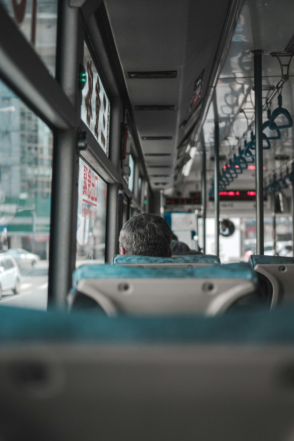 Mann im schwarzen Hemd sitzt auf Bussitz