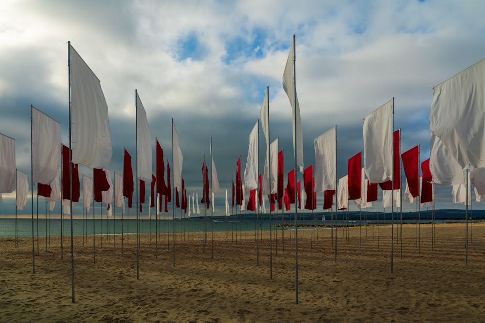 flags on gray metal fence under white clouds during daytime