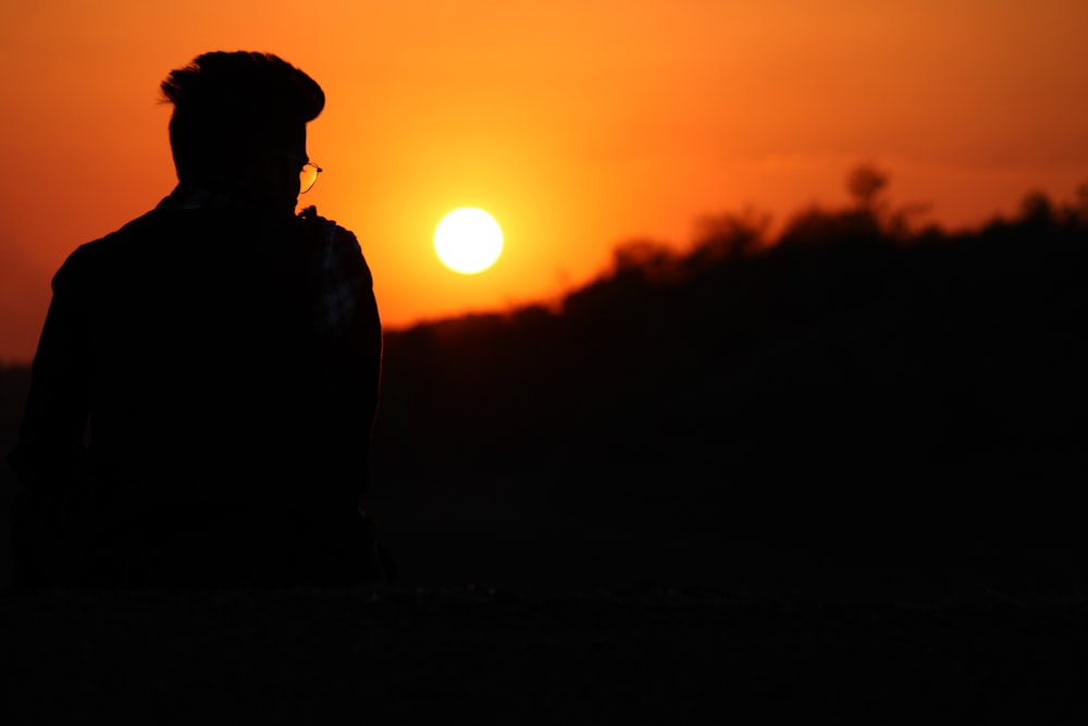 silhouette of man standing during sunset