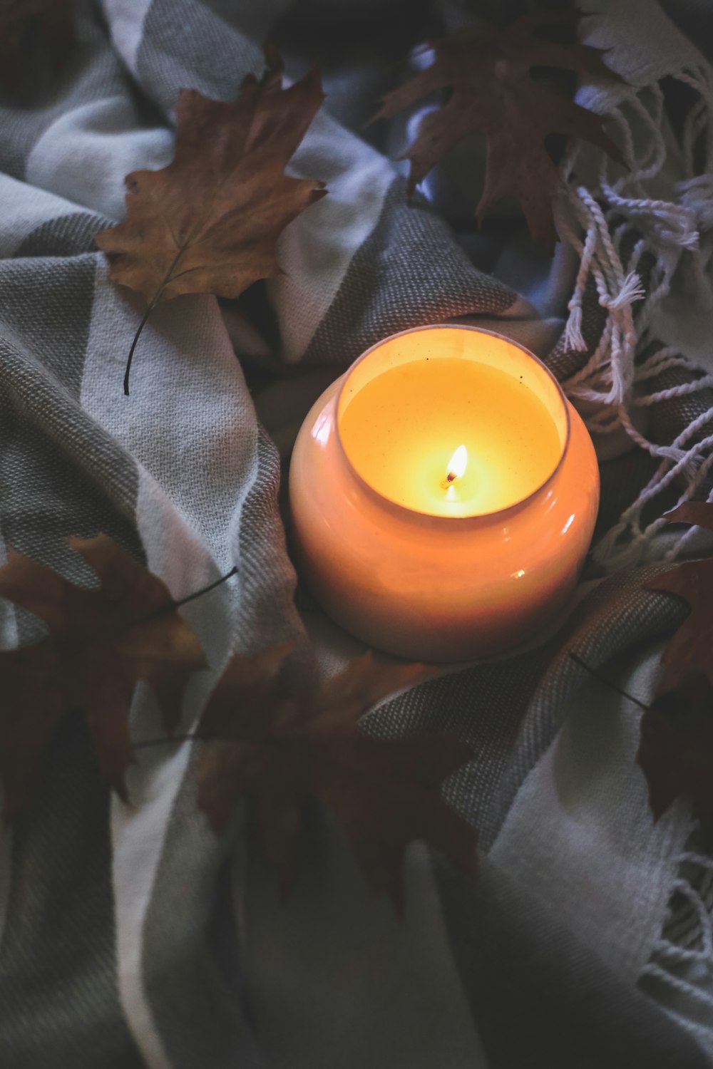 white candle on brown textile