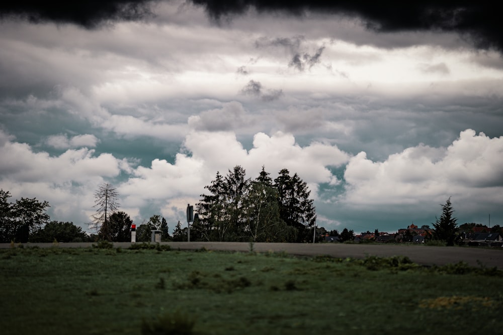 green grass field under cloudy sky during daytime