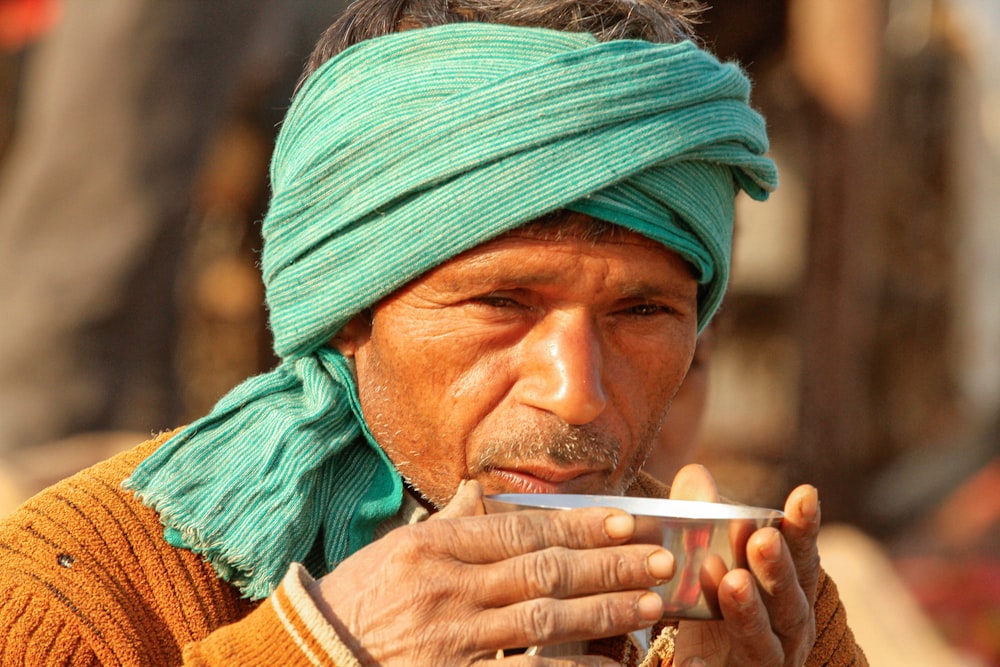 man in green and brown turban smoking cigarette