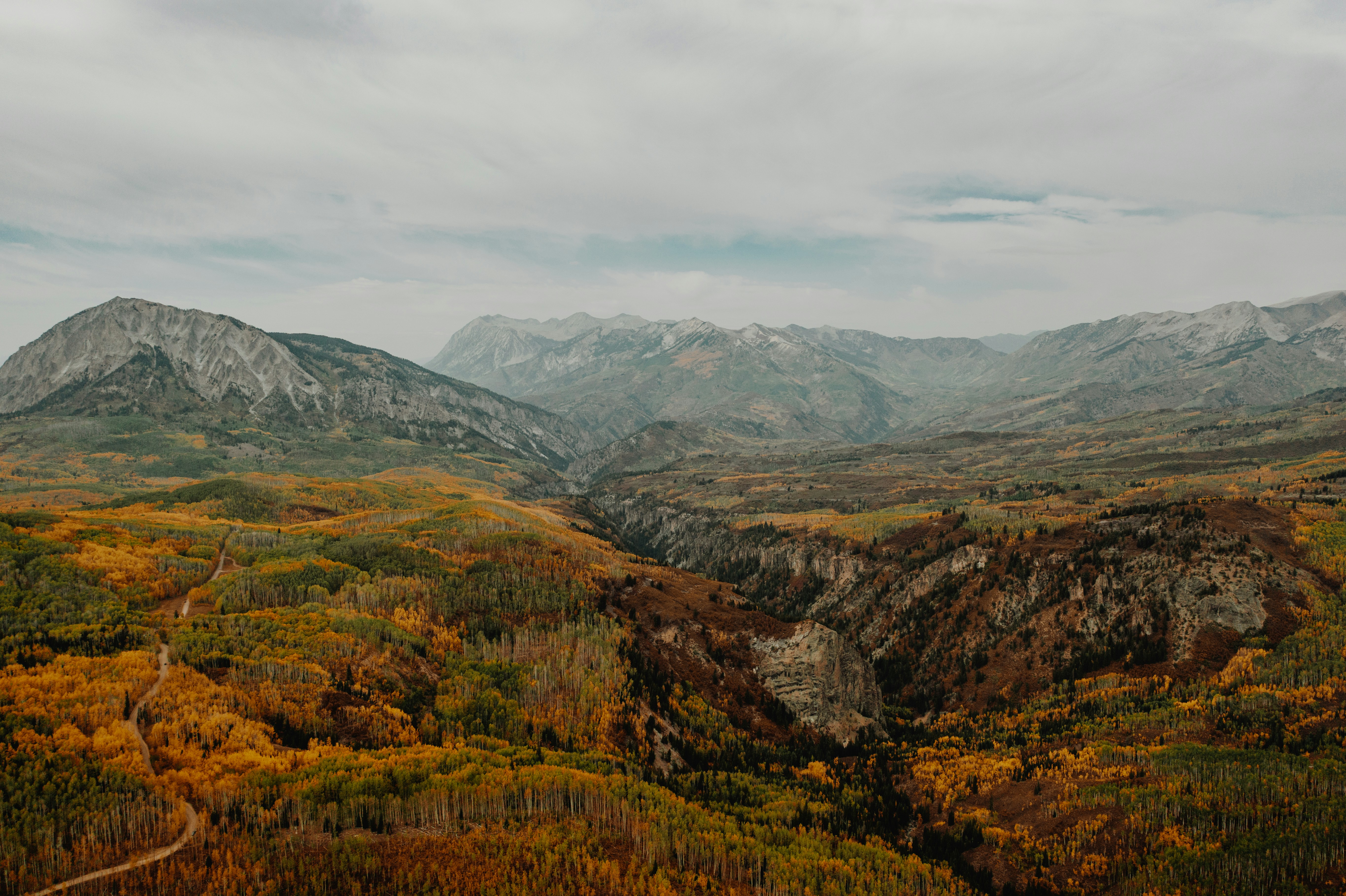 grüne und braune Berge unter weißen Wolken tagsüber