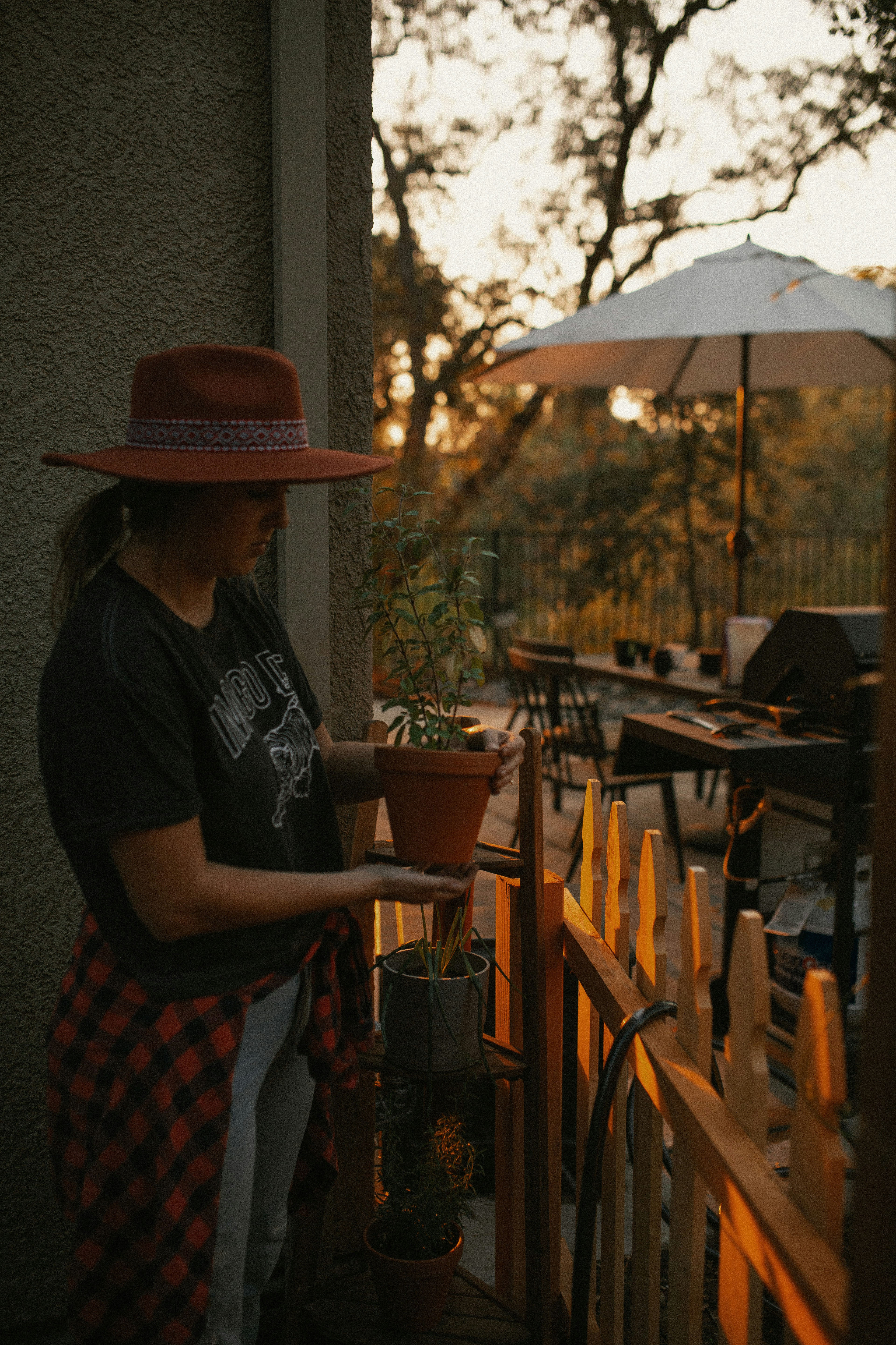 woman in black t-shirt and red and blue plaid skirt standing near brown wooden table