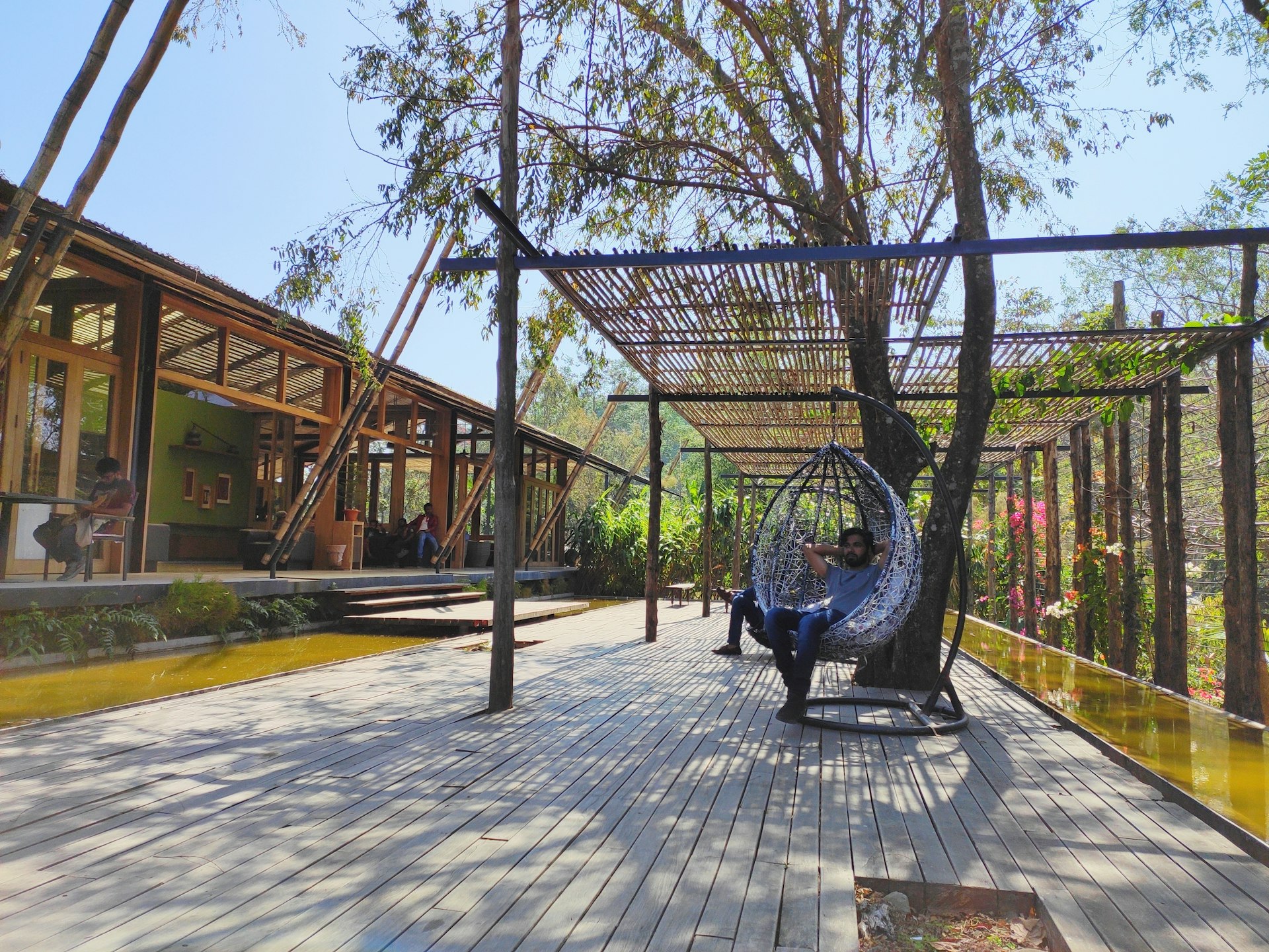 Black metal swing bench near a wooden fence, ideal for relaxation