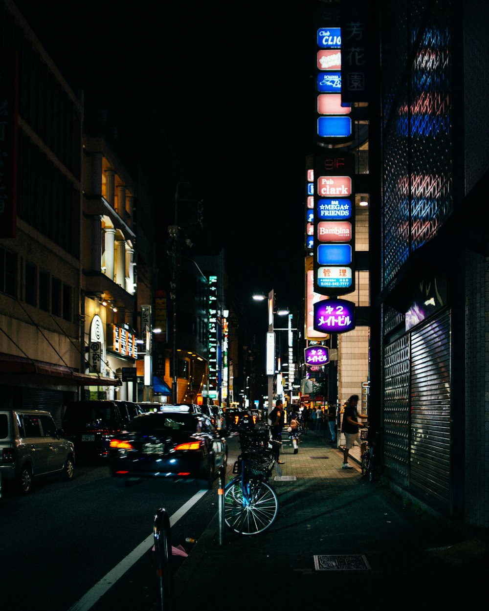검은 재킷을 입은 남자가 밤 시간에 도로에서 자전거를 타고 있다
