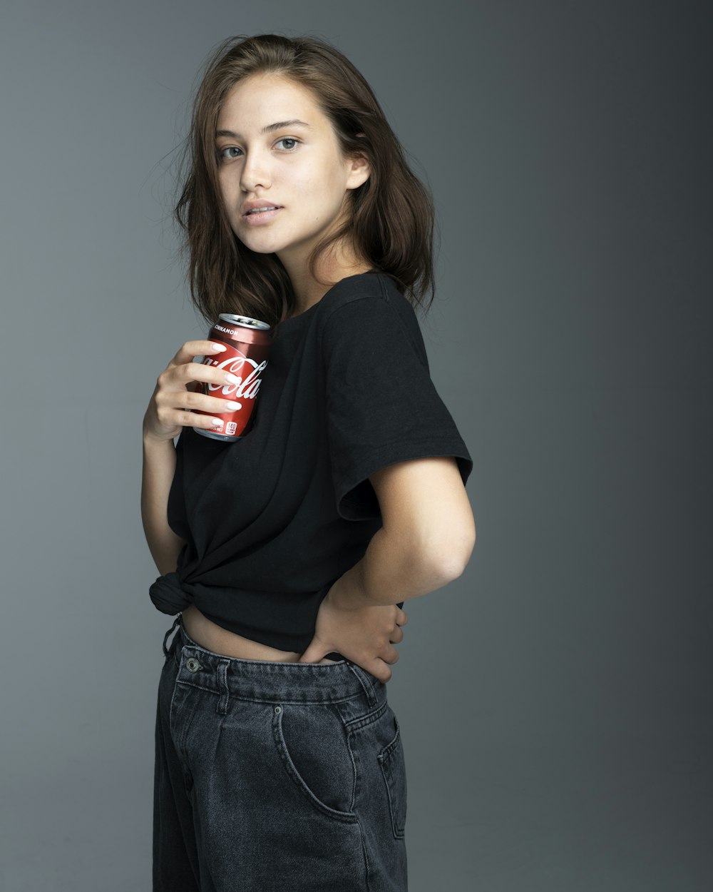 woman in black crew neck t-shirt holding coca cola can