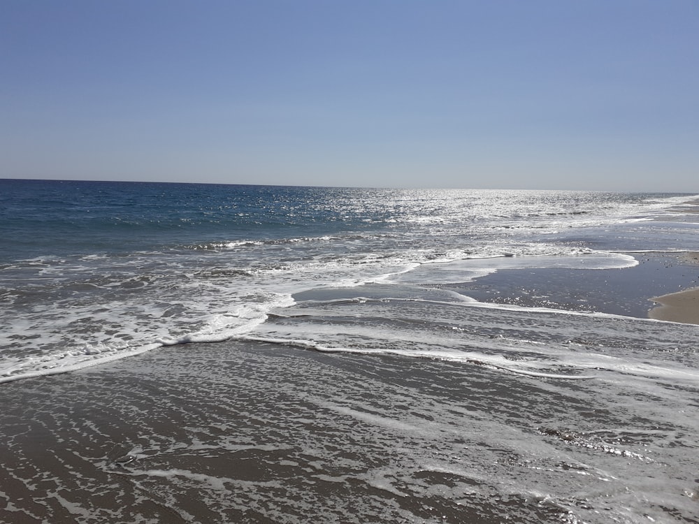 ocean waves crashing on shore during daytime