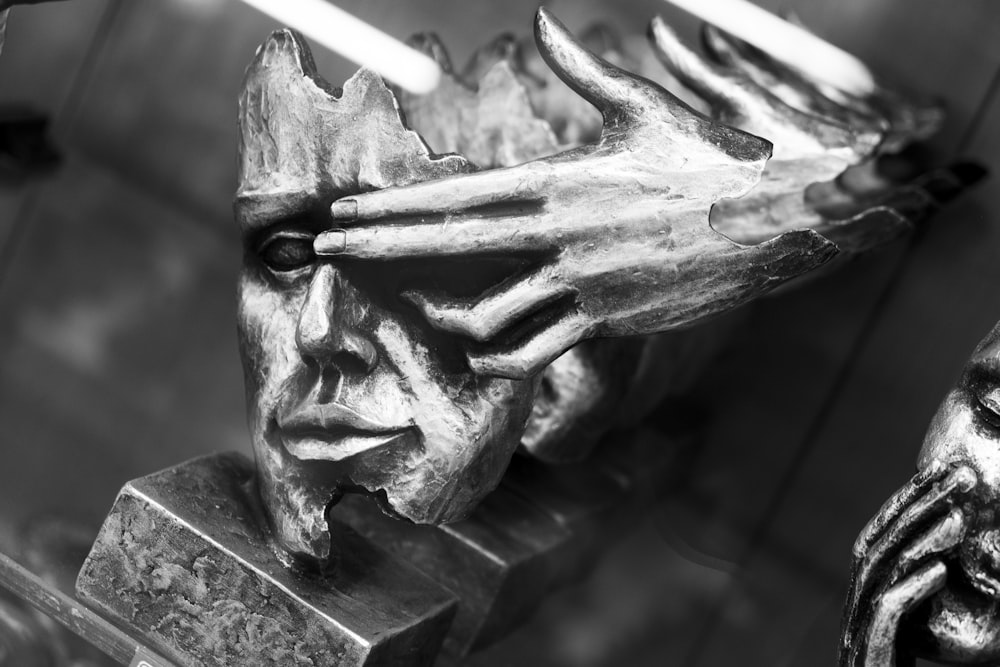 a black and white photo of a sculpture of a man's face