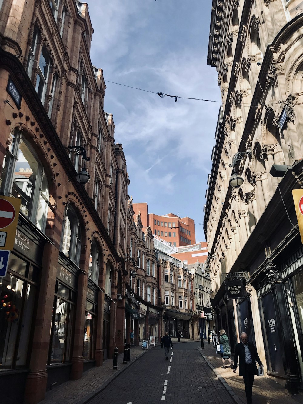 a city street lined with tall buildings under a blue sky